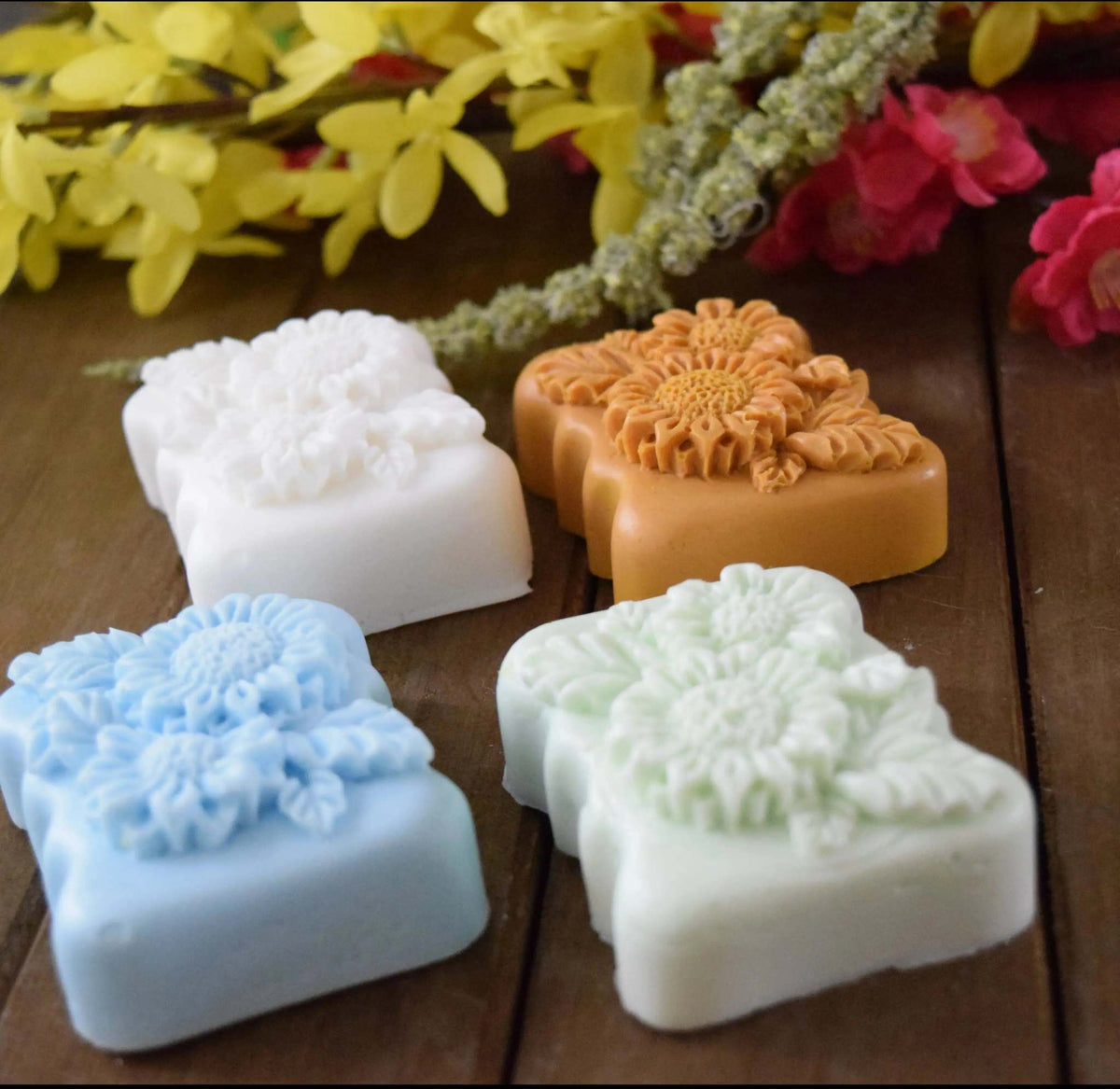 Handcrafted small-batch soaps in white, tan, blue, and pale green with intricate floral patterns to Choose your Soap design.