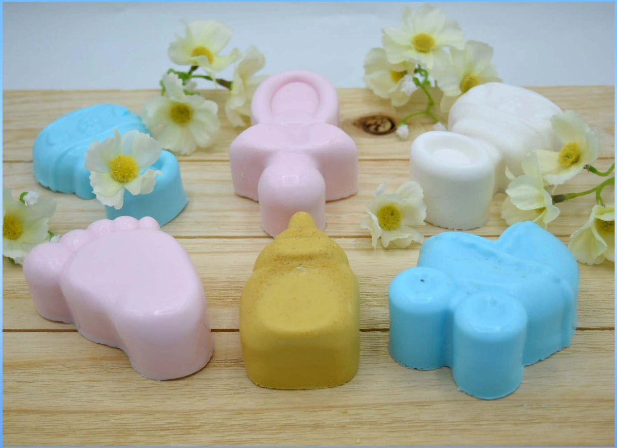 Handcrafted pastel-colored baby-themed soaps in pink, blue, white, and yellow with floral accents to Choose your Soap design.