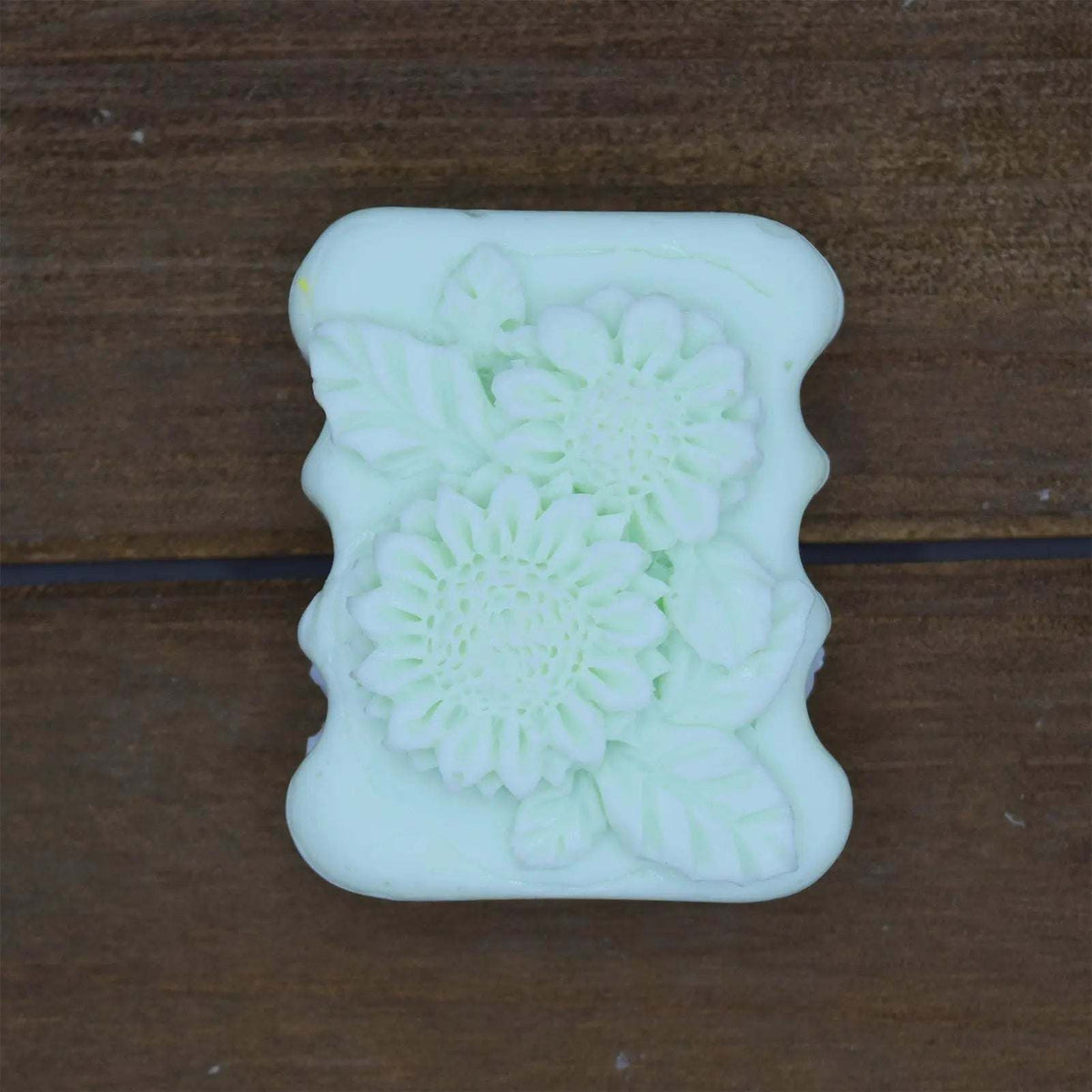 Decorative Natural Crafted soap in pale green with floral and leaf embossed design on a rectangular bar.