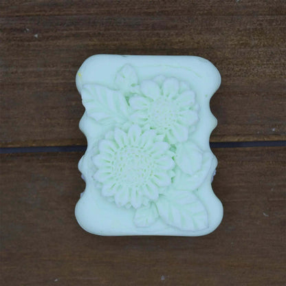 Decorative Natural Crafted soap in pale green with floral and leaf embossed design on a rectangular bar.