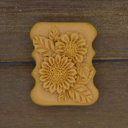 Decorative Natural Crafted soap with a rectangular shape, mustard yellow color, and raised sunflower and leaf design on top