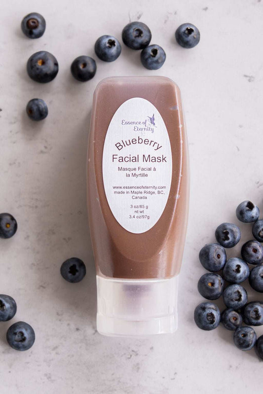 Blueberry facial mask in a jar from Essence of Eternity, showing a vibrant blue mask with fresh blueberries around it.