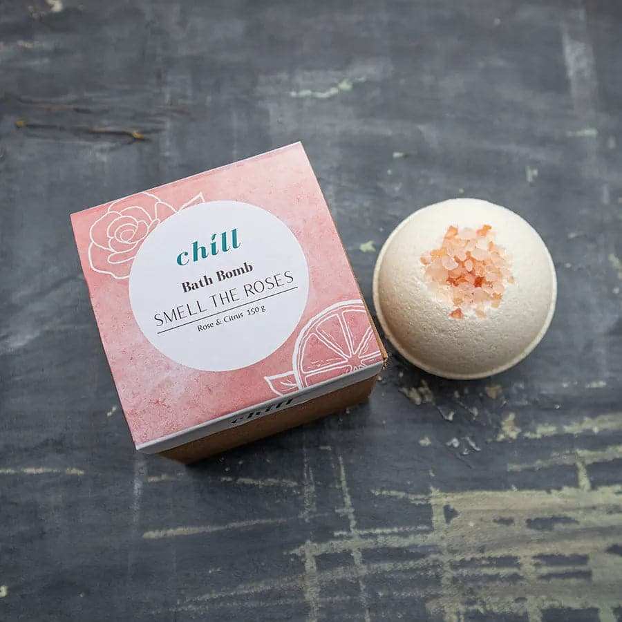 Smell the Roses bath bomb in light pink with salt crystals on top, featuring rose and citrus scents in round shape.