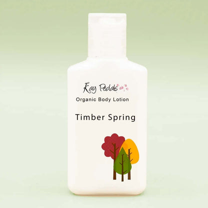 Small white plastic bottle of Kay Pedals Scent Discovery Trio organic body lotion in Timber Spring scent with tree graphic on front