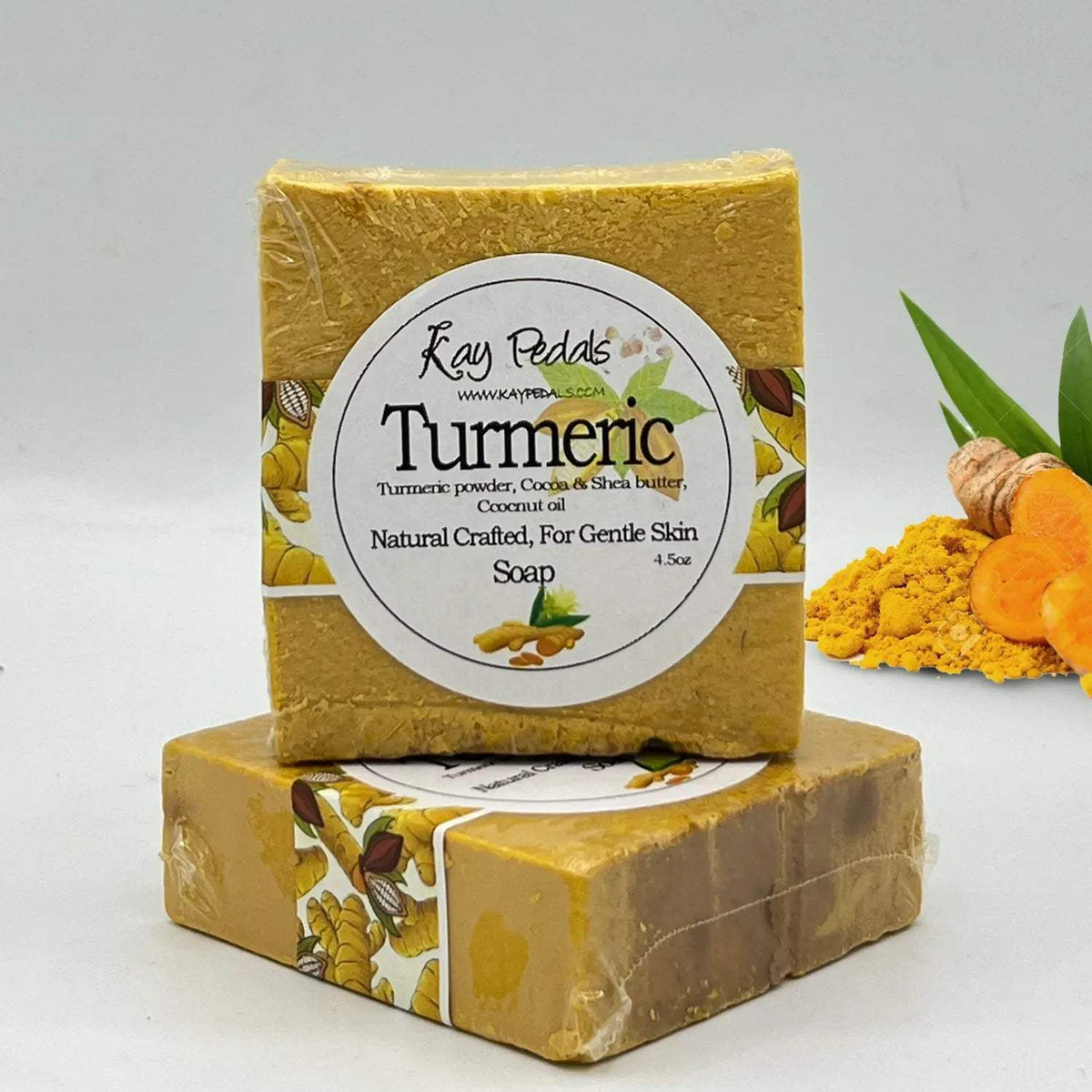 Turmeric natural crafted bar soap in yellow with natural ingredients label, cocoa and shea butter, wrapped in plastic.