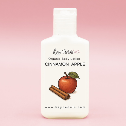 White plastic travel-size lotion bottle with "Cinnamon Apple" scent label, featuring an apple and cinnamon sticks illustration for Kay Pedals Scent Discovery Trio.