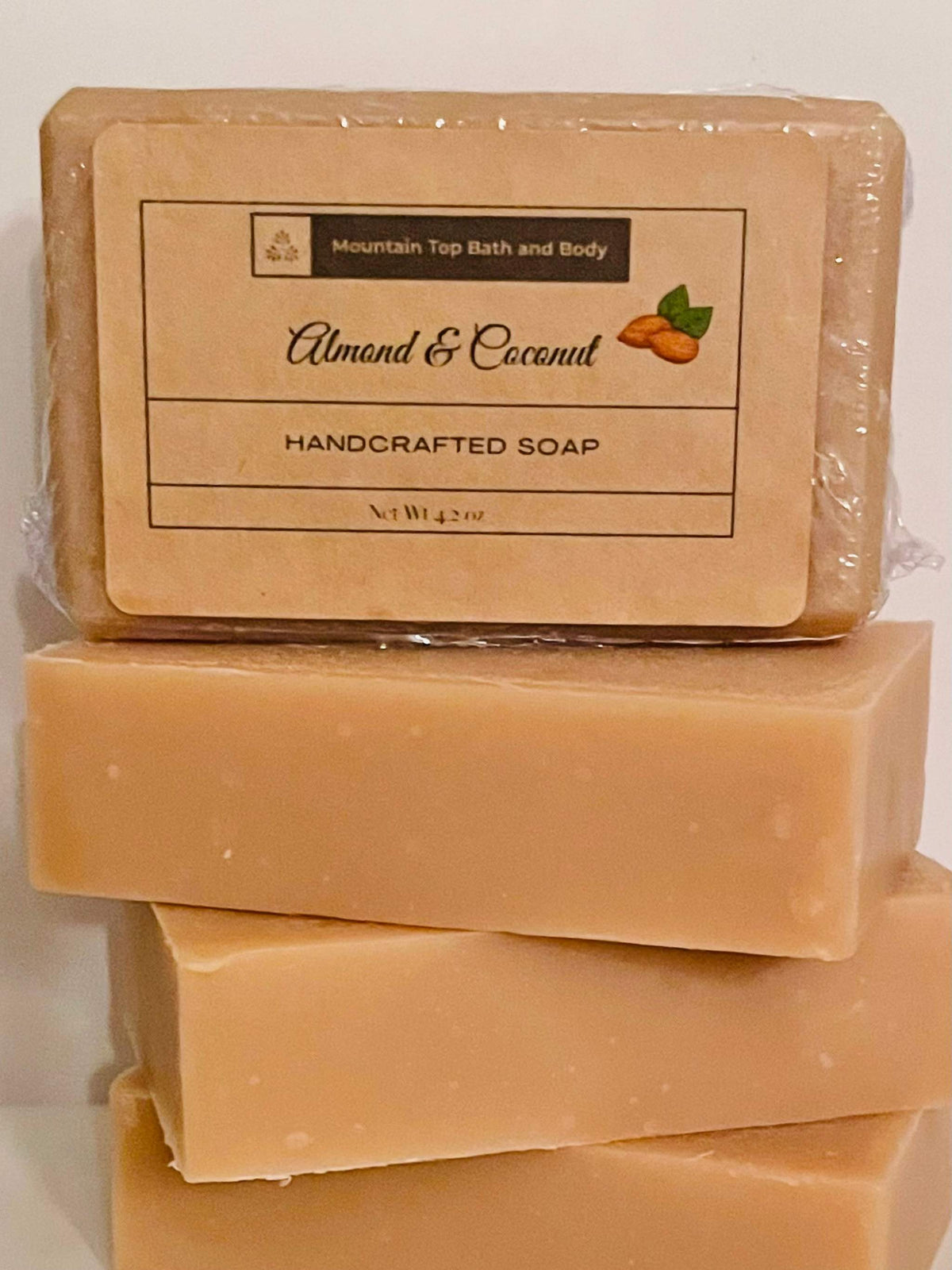 Handcrafted Almond & Coconut soap bar in beige with a simple rectangular shape and a label featuring almond illustration.