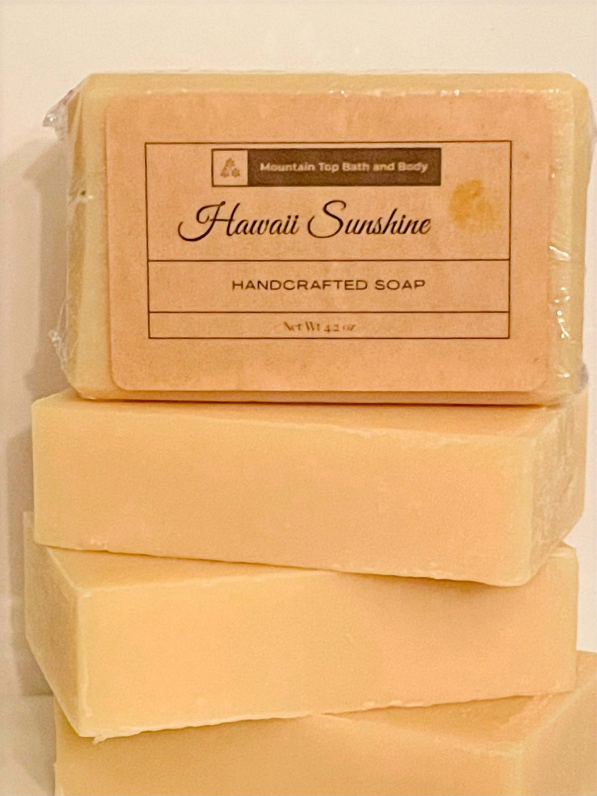Hawaii Sunshine handcrafted soap bars in light peach color with simple rectangular shape and smooth texture stacked together