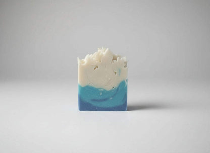 Artisanal Winter Blue Soap bar with layered blue and white swirls, featuring a textured top edge and smooth base.