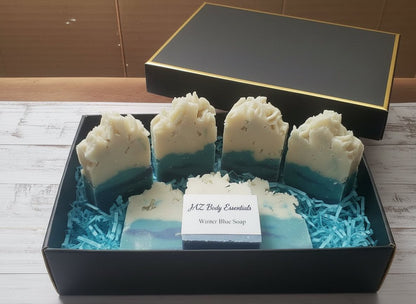 Winter Blue Soap bars in blue and white gradient with textured tops, presented in a black gift box with blue shredded paper lining.